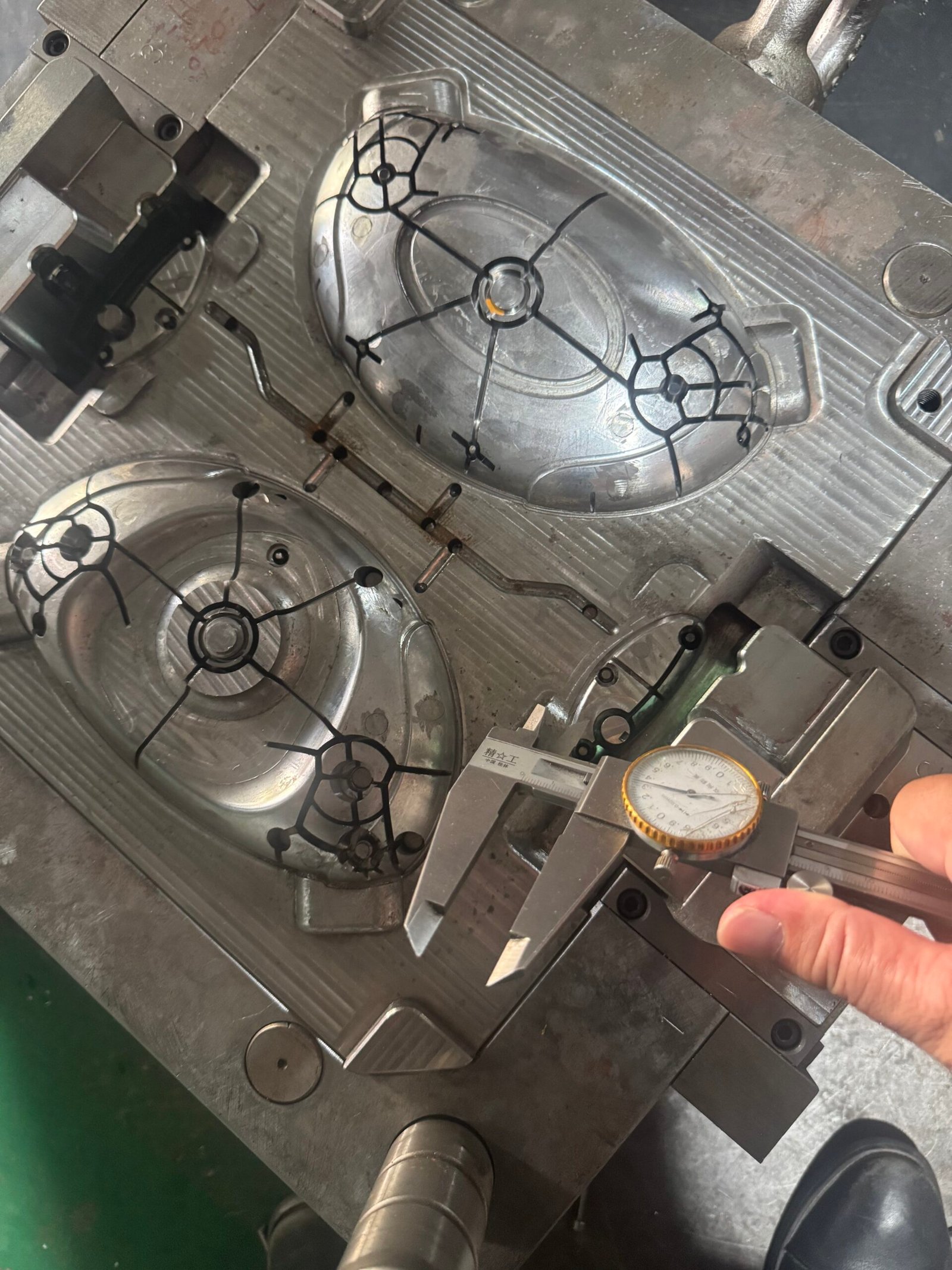 Injection mold cavity for the ABS grille trim component during tooling review and dimensional checking.