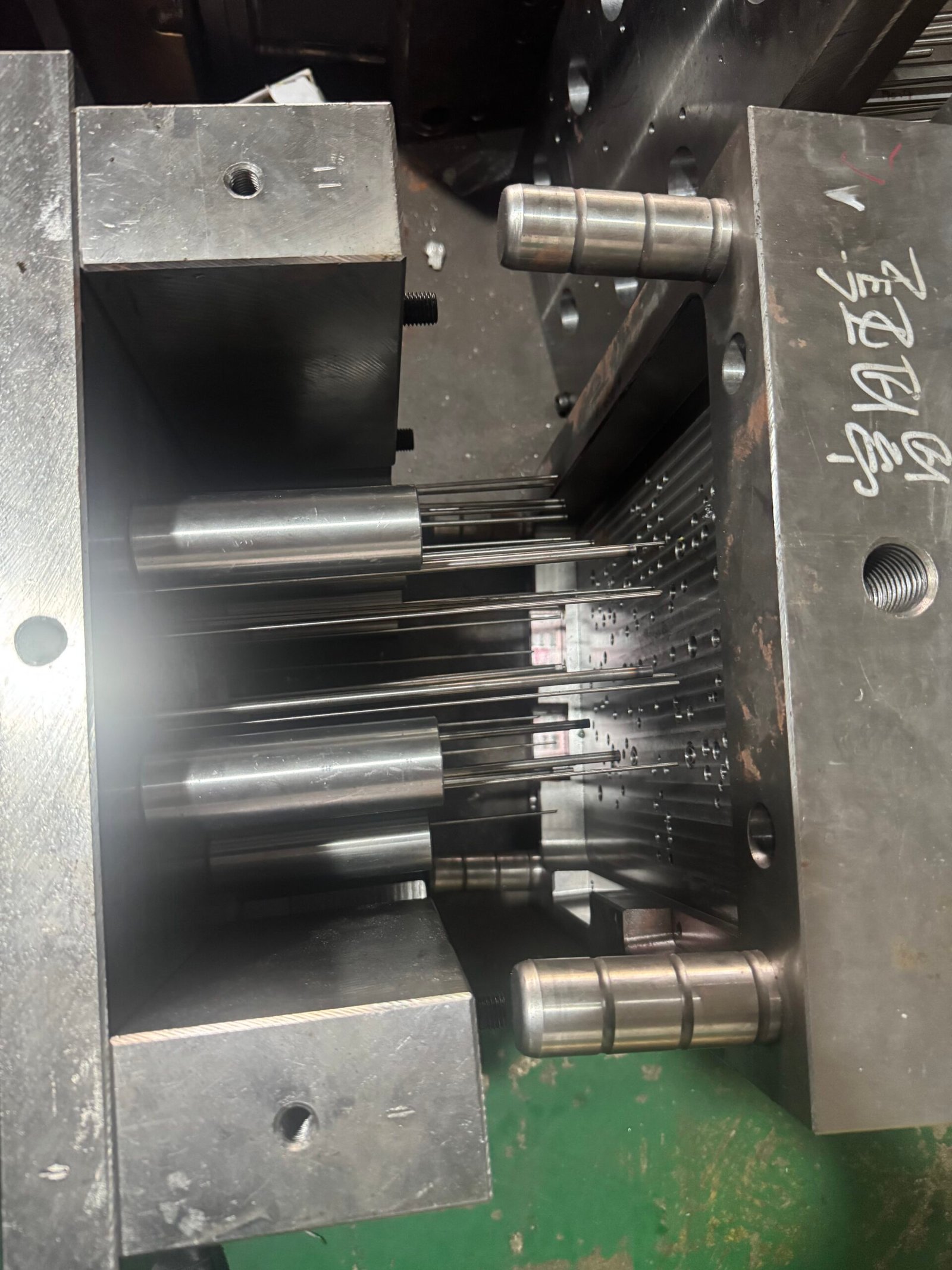 Open injection mold showing core inserts and ejector pins for the ABS grille trim component.